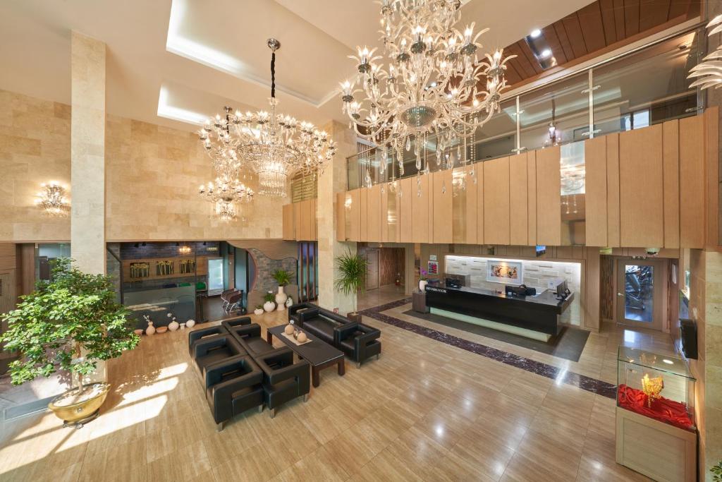 a large living room with chandeliers and black furniture at Gyeongju GG Tourist Hotel in Gyeongju