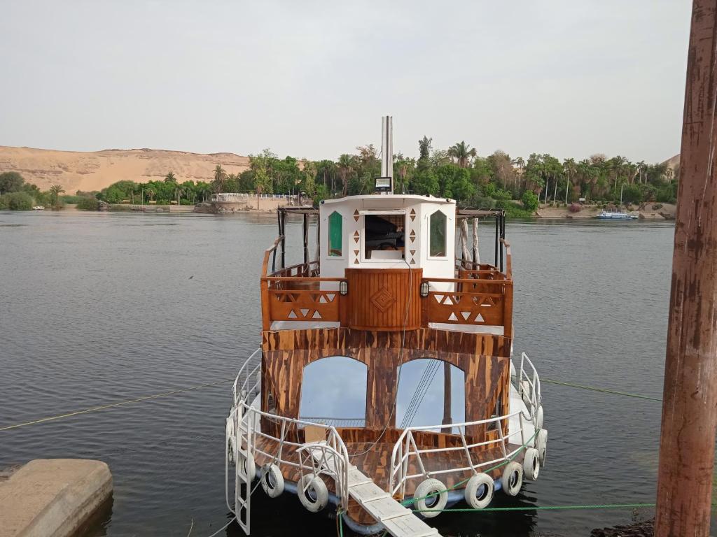 a small boat sitting in the water at Houseboat Hotel and Nile Cruises Zainoba in Nag` el-Ramla