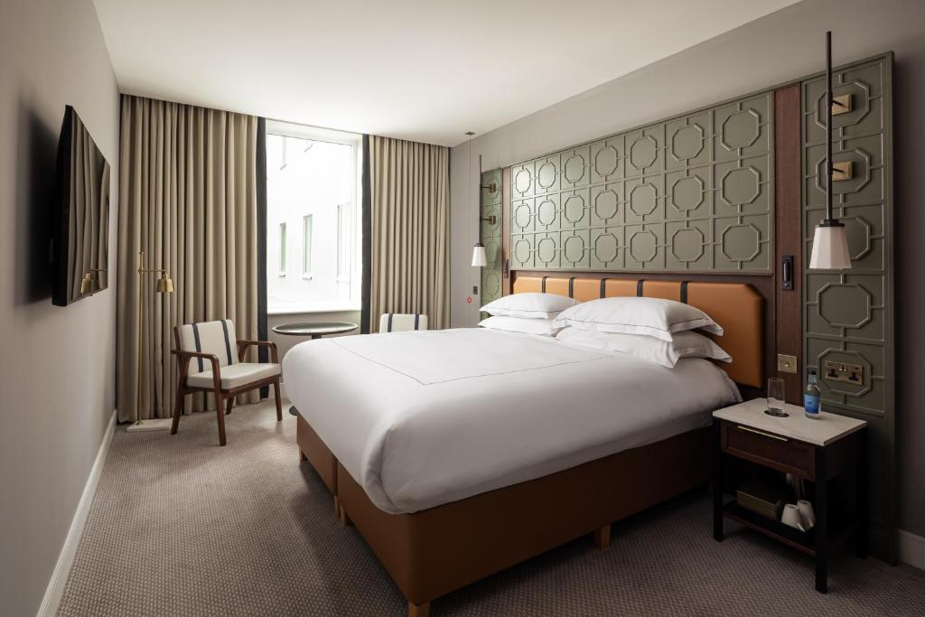 a hotel room with a large bed and a table at The Parkgate Hotel in Cardiff