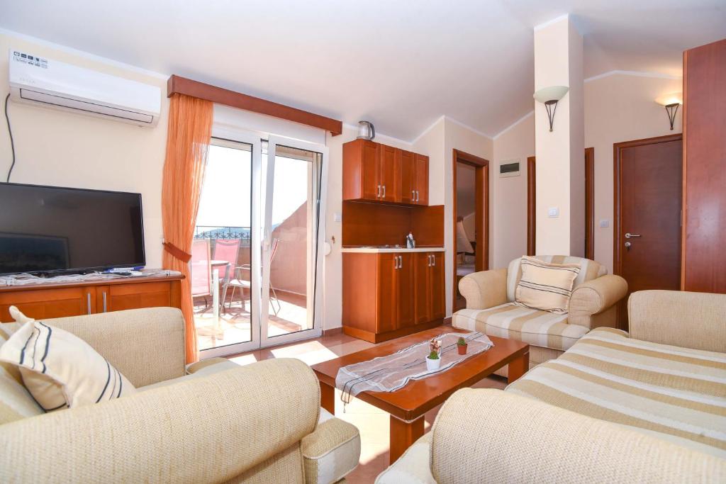 a living room with two couches and a television at Apartments Villa Sveti Nikola in Budva