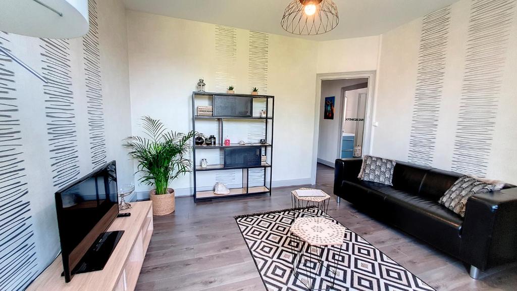 sala de estar con sofá y mesa en Appartement F2 refait à neuf tout confort, en Montluçon