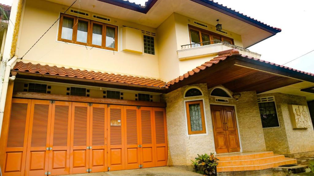 ein Haus mit orangefarbenen Garagentüren in der Unterkunft Dago Asri House (3 Bedrooms, 6 Pax, 500m2) in Bandung
