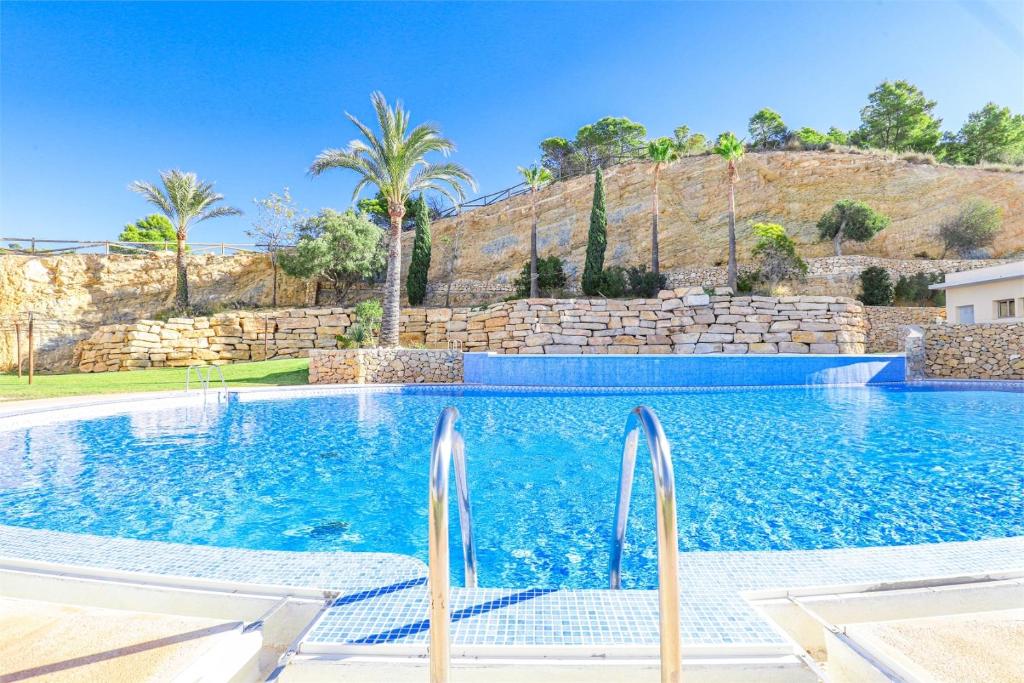 uma piscina numa villa com palmeiras em Apartment with private balcony and nice views 23 em Benidorm