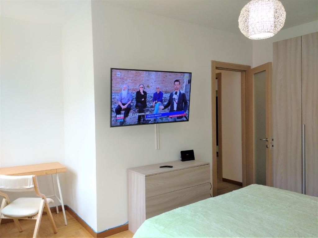 sypialnia z telewizorem z płaskim ekranem na ścianie w obiekcie La Rosa del Lago w mieście Omegna