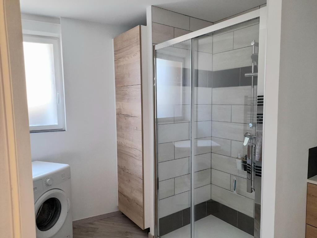 a bathroom with a shower and a washing machine at Le travers (centre ville Joigny) in Joigny