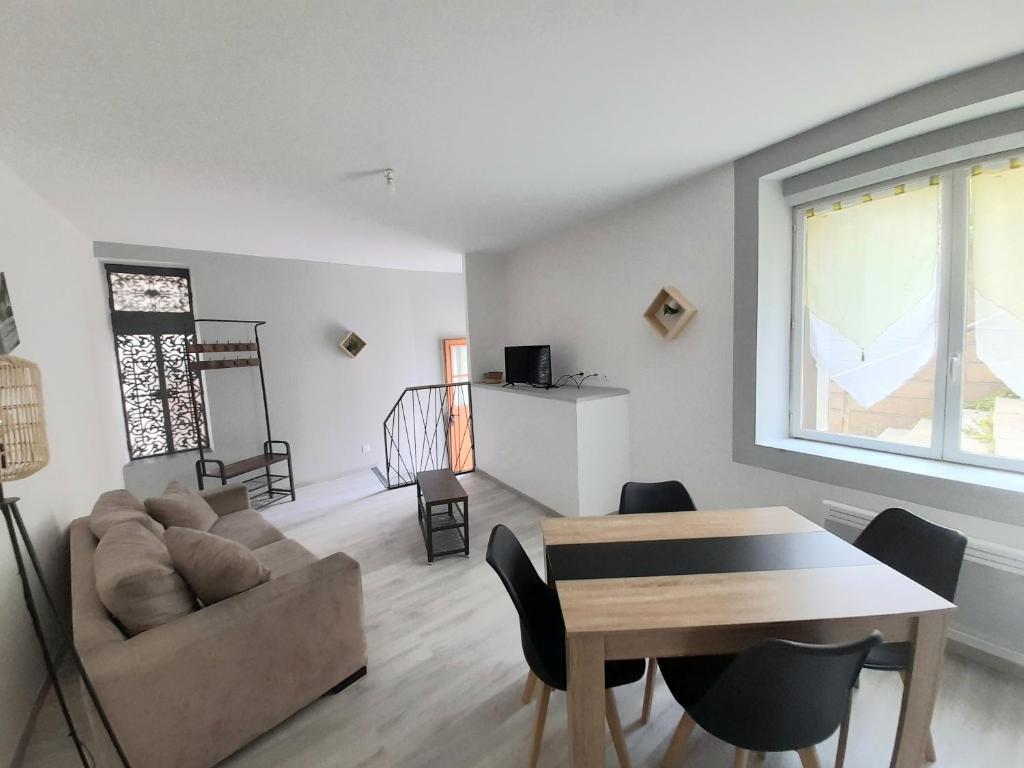 a living room with a couch and a table at Le travers (centre ville Joigny) in Joigny