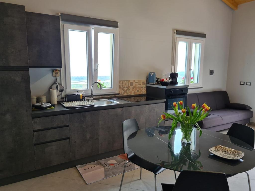 cocina y sala de estar con mesa y sofá en Profumo di Zagara, en Fiumefreddo di Sicilia