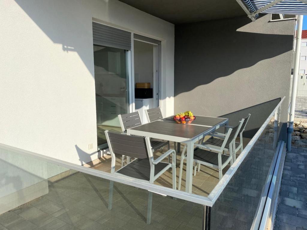 a table and chairs on the balcony of a house at Amazing Simuni 2 in Šimuni