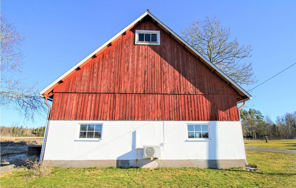 un granero rojo y blanco con techo rojo en Beautiful Home In Grimslv With Sauna, en Grimslöv