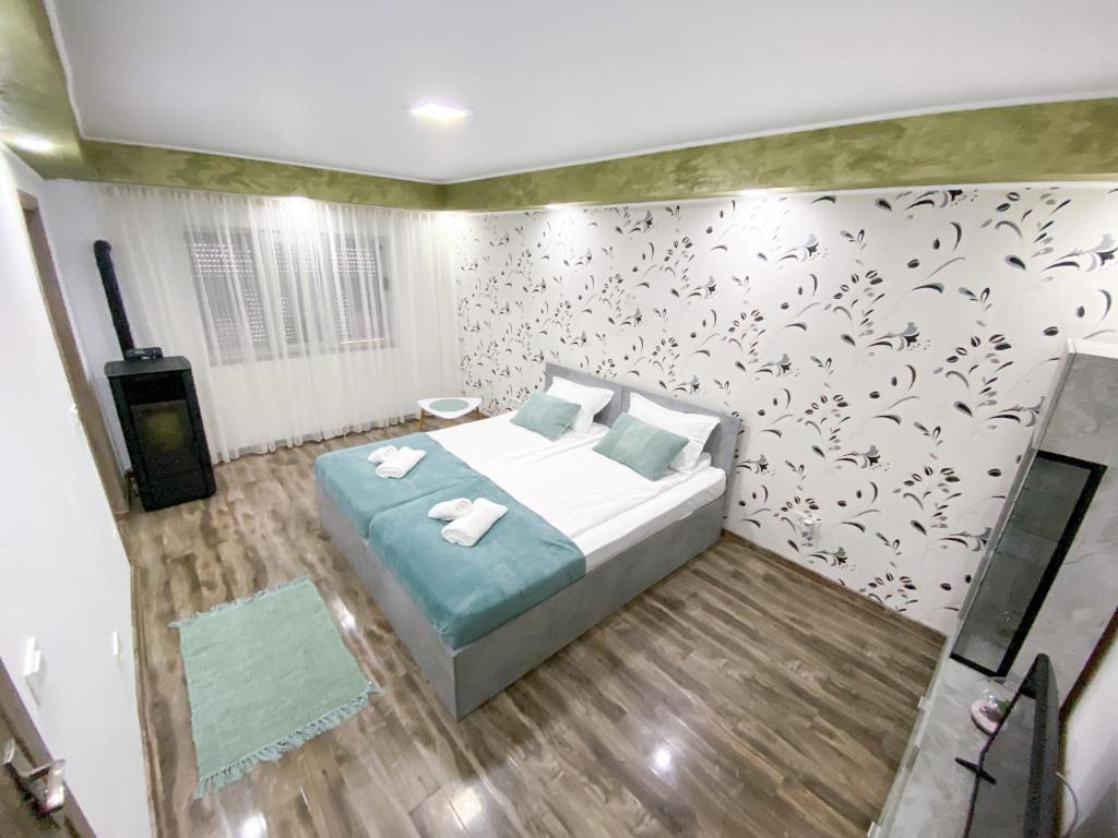 ein Schlafzimmer mit einem Bett und einer Wand mit Blumen in der Unterkunft Apartament la Malul Dunării in Moldova Veche