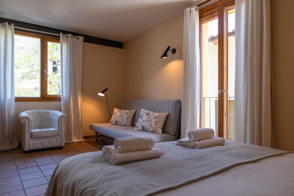a bedroom with a large bed and a couch at Casa La Vera Rural in Talaveruela