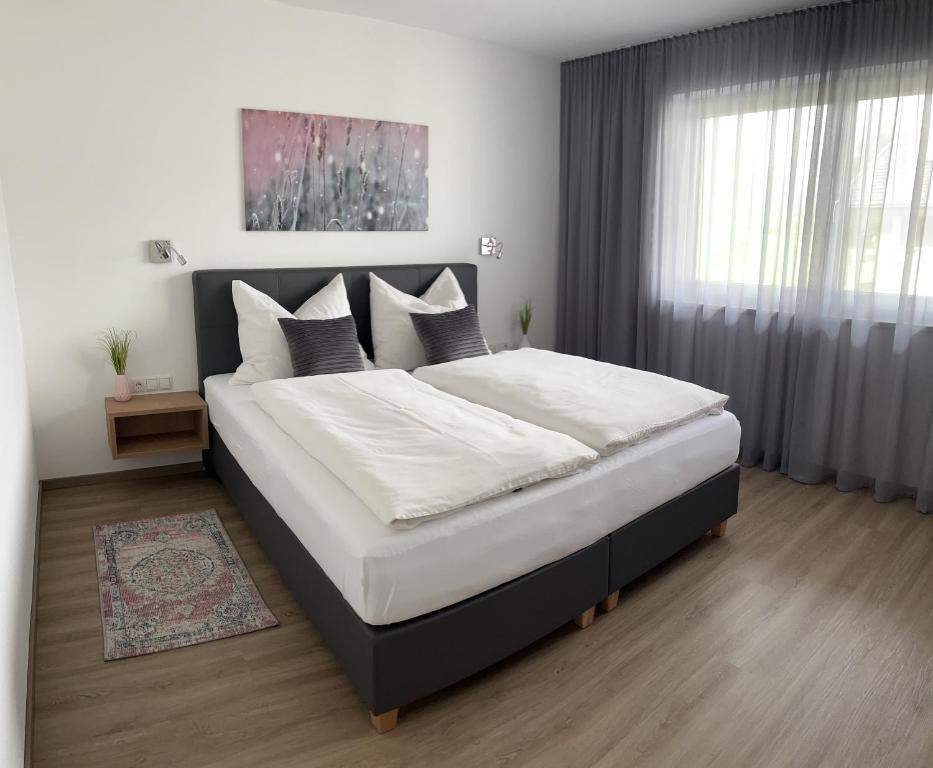 a bedroom with a large bed with white sheets and pillows at Ferienwohnung Ott in Ebbs