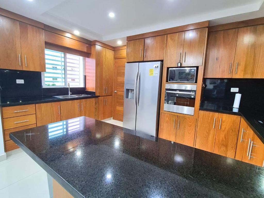 a kitchen with wooden cabinets and a stainless steel refrigerator at Fully equipped apartment with sea view in La Viva