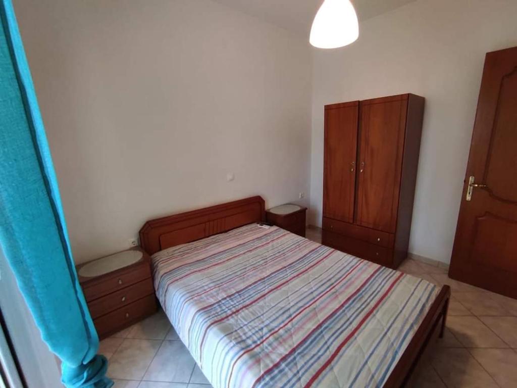 Dormitorio pequeño con cama y armarios de madera en Basilis room, en Loutsa