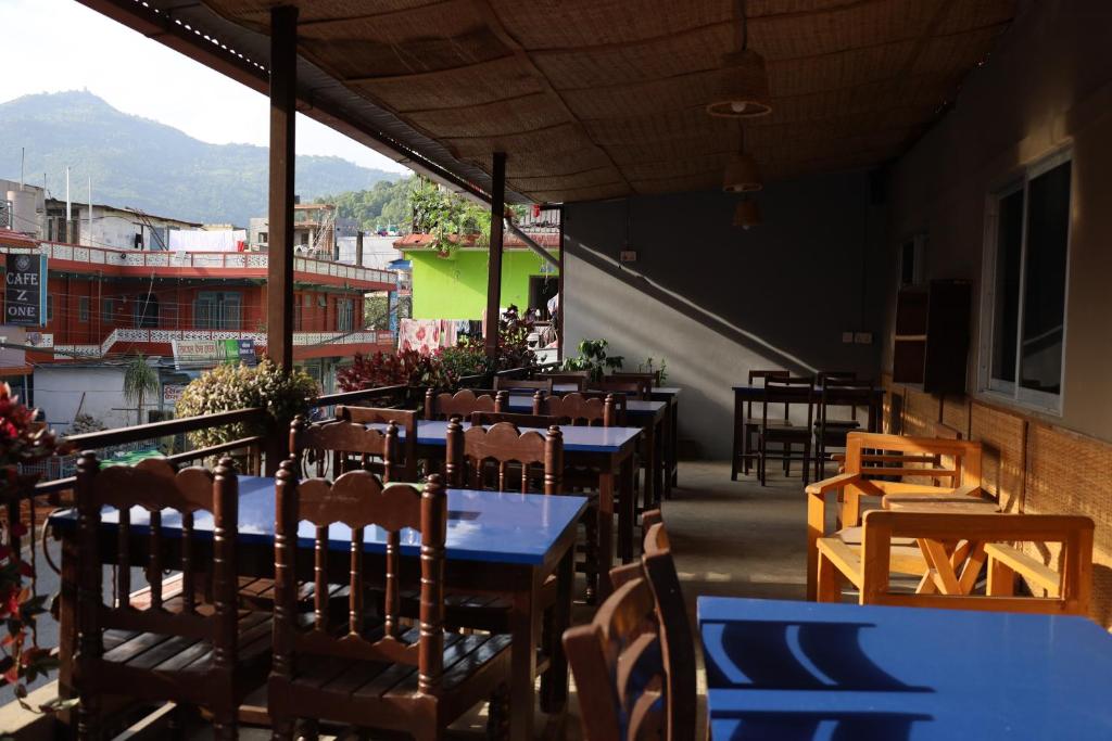 un ristorante con tavoli e sedie su un balcone di Margik Backpackers Hostel a Pokhara
