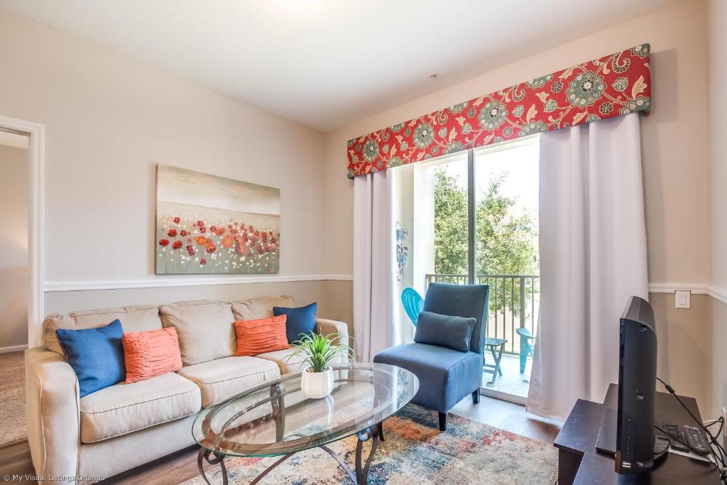 een woonkamer met een bank en een glazen tafel bij Spacious Vista Cay Condo, near Resort Pool in Orlando