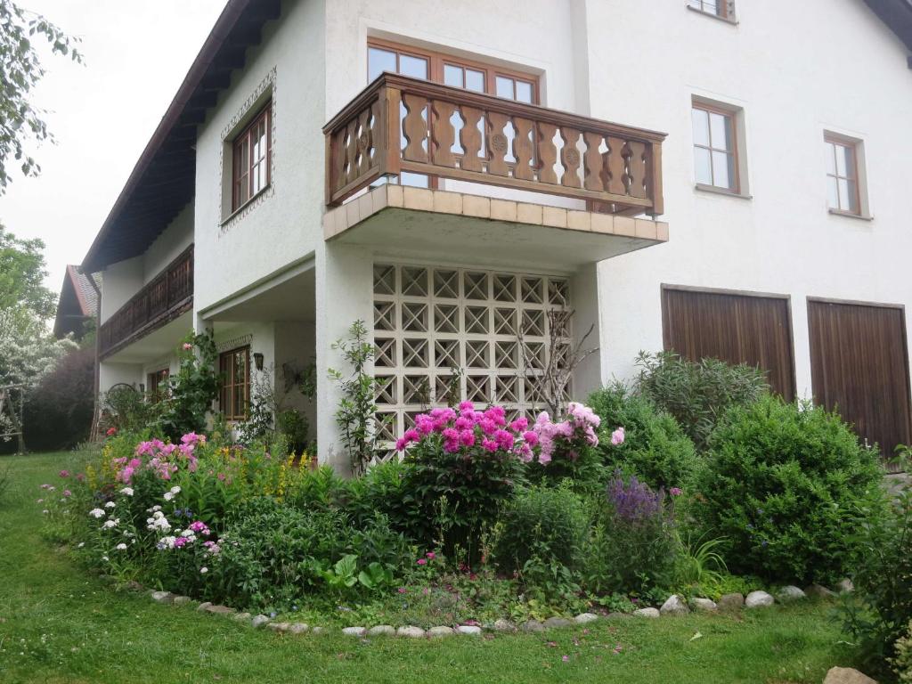 ein Haus mit einem Balkon und Blumen im Hof in der Unterkunft Ferienwohnung Birkenflair in Seebruck