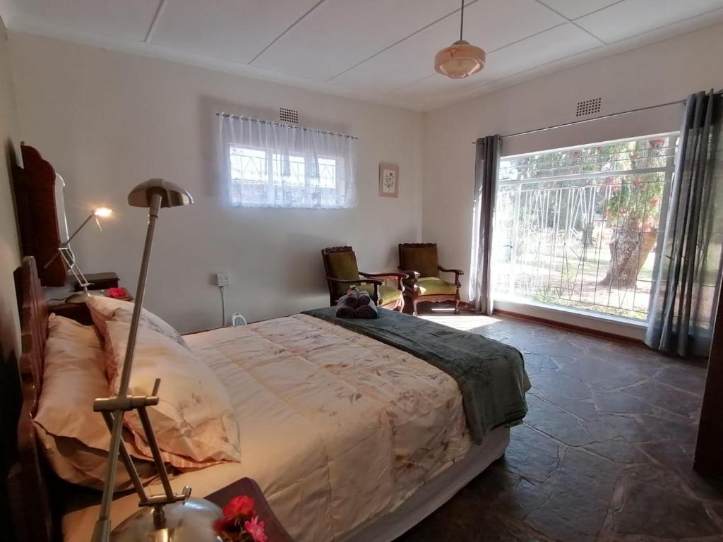 a bedroom with a large bed and a large window at Doornspruit Farm in Magaliesburg