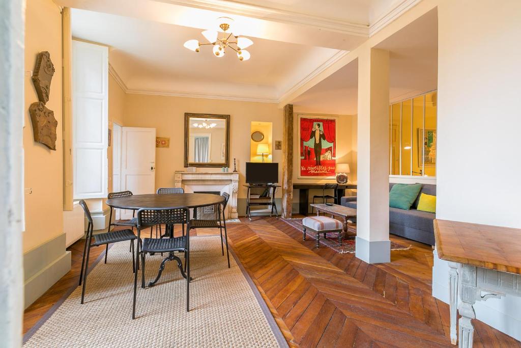 une salle à manger et un salon avec une table et des chaises dans l'établissement Le Saint Michel, à Dijon