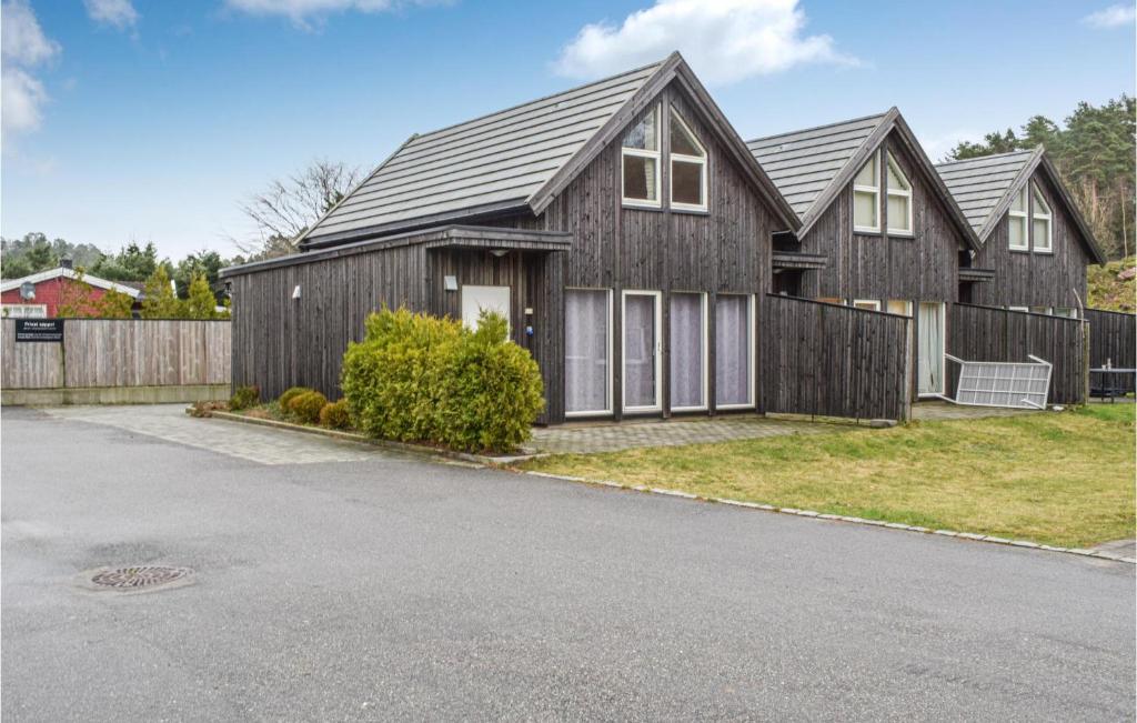 une grande maison en bois avec une clôture dans l'établissement Beautiful Home In Sgne With House A Panoramic View, à Søgne