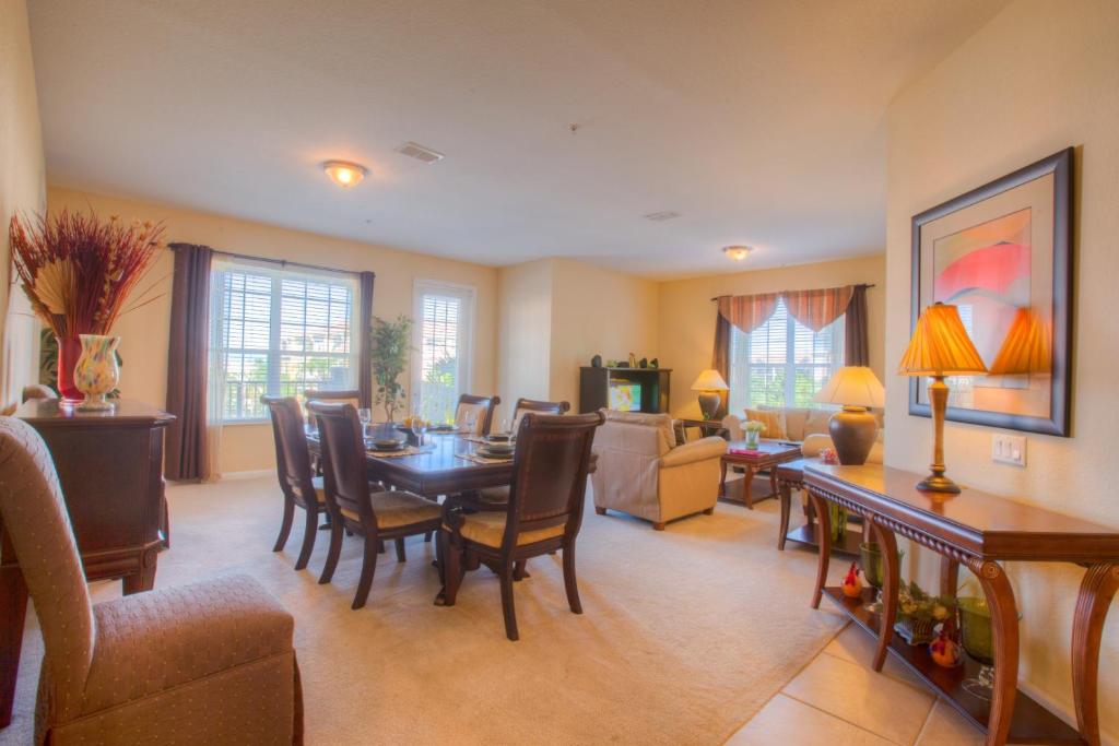 sala de estar con mesa de comedor y sillas en Lovely Third-Floor Vista Cay Resort Condo en Orlando