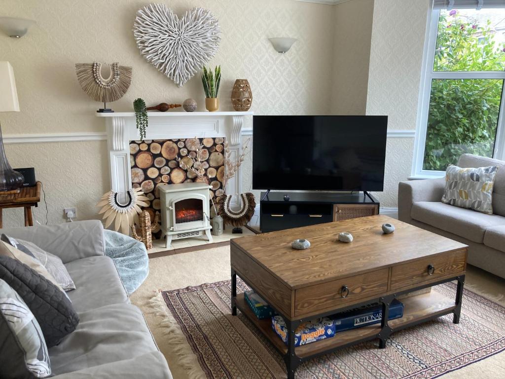 a living room with a couch and a tv and a fireplace at 99 Tower Road in Newquay