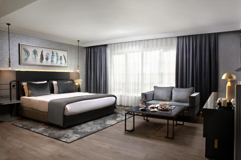 um quarto com uma cama, um sofá e uma mesa em The Wings Hotels Neva Palas em Ancara