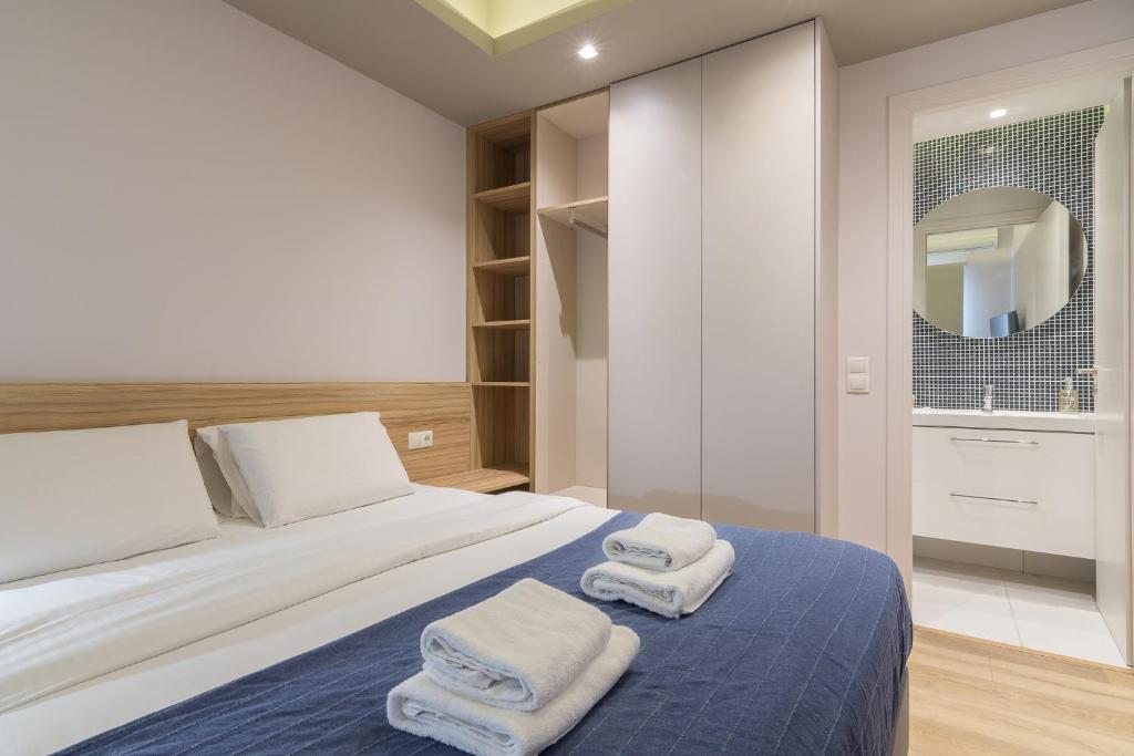 een slaapkamer met een bed met handdoeken erop bij Kolokotroni Lofts Syntagma in Athene