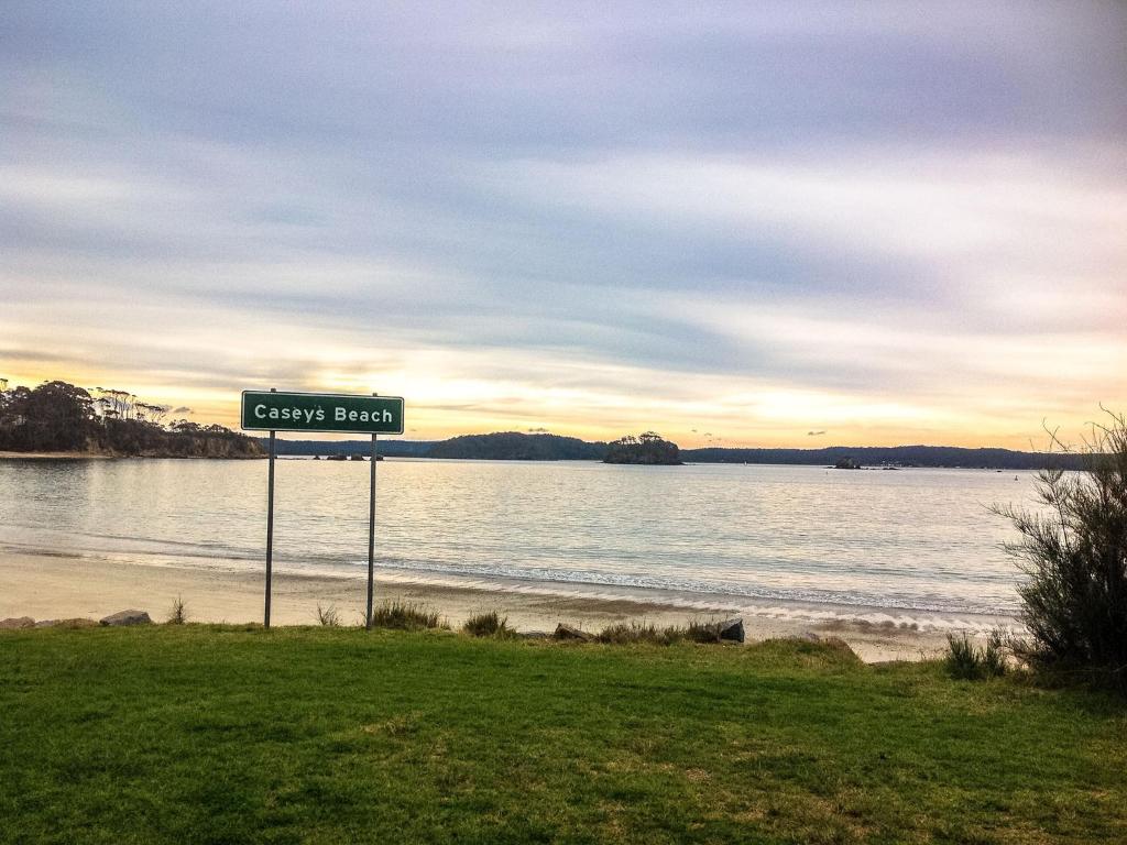 a sign that reads clays bluff next to a beach at Caseys Beach Holiday Park in Sunshine Bay