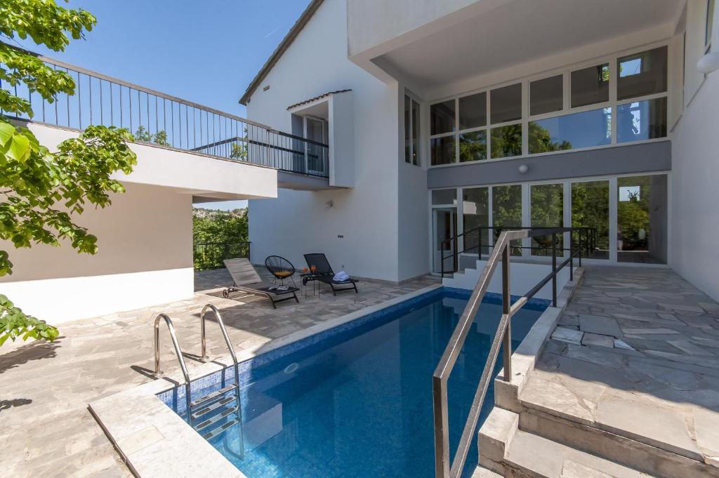 a house with a swimming pool and a patio at Villa Green Castle in Zadvarje