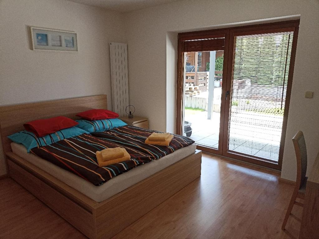 a bedroom with a bed and a sliding glass door at Ubytování U Vrbičky - blízko Prahy in Unhošť