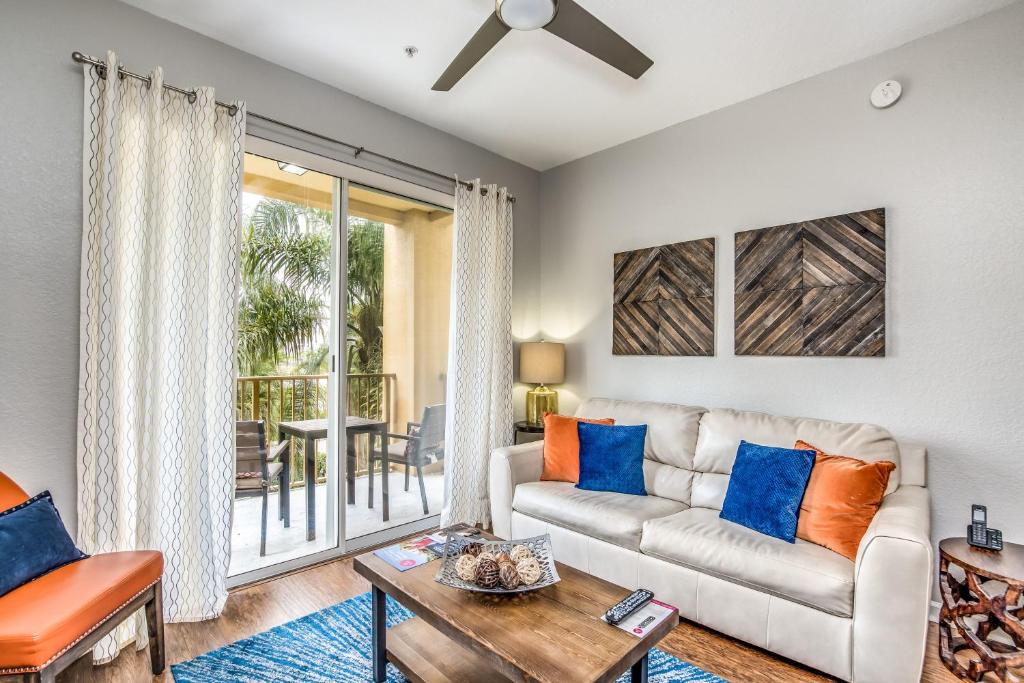 een woonkamer met een bank en een tafel bij Newly Updated Condo w Scenic Resort View in Orlando