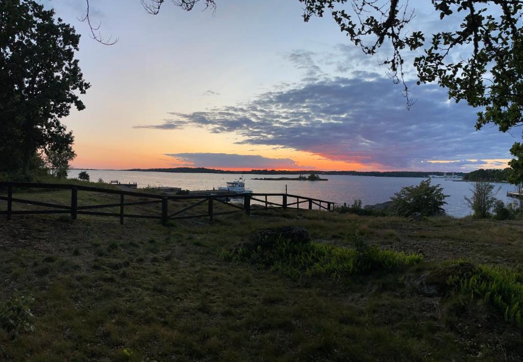 a sunset on a lake with a boat in the water at Aspan Kurs & Lägergård in Ronneby