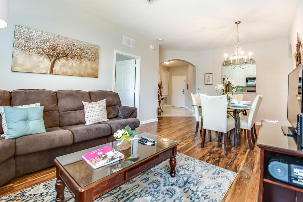 ein Wohnzimmer mit einem Sofa und einem Tisch in der Unterkunft Stylish Vista Cay Condo, near Orlando attractions in Orlando