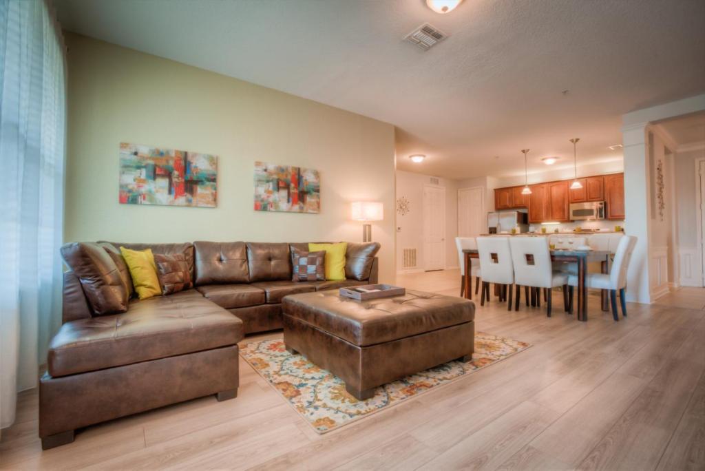 a living room with a brown couch and a table at Beautiful LAKEVIEW Deluxe Condo Near Theme Parks in Orlando