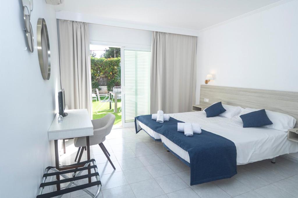 a bedroom with a bed and a table and a desk at NURA Apartments - Condor in Palma de Mallorca