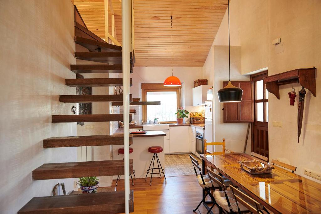 a kitchen and dining room with a spiral staircase in a house at Casa Urbión-Pinares de Soria in Covaleda