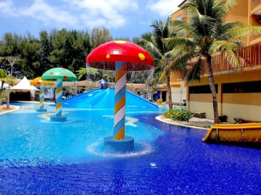 een zwembad in een resort met een rode paddestoel bij 5pax Gold Coast Morib Resort - Banting Sepang KLIA Tanjung Sepat in Banting