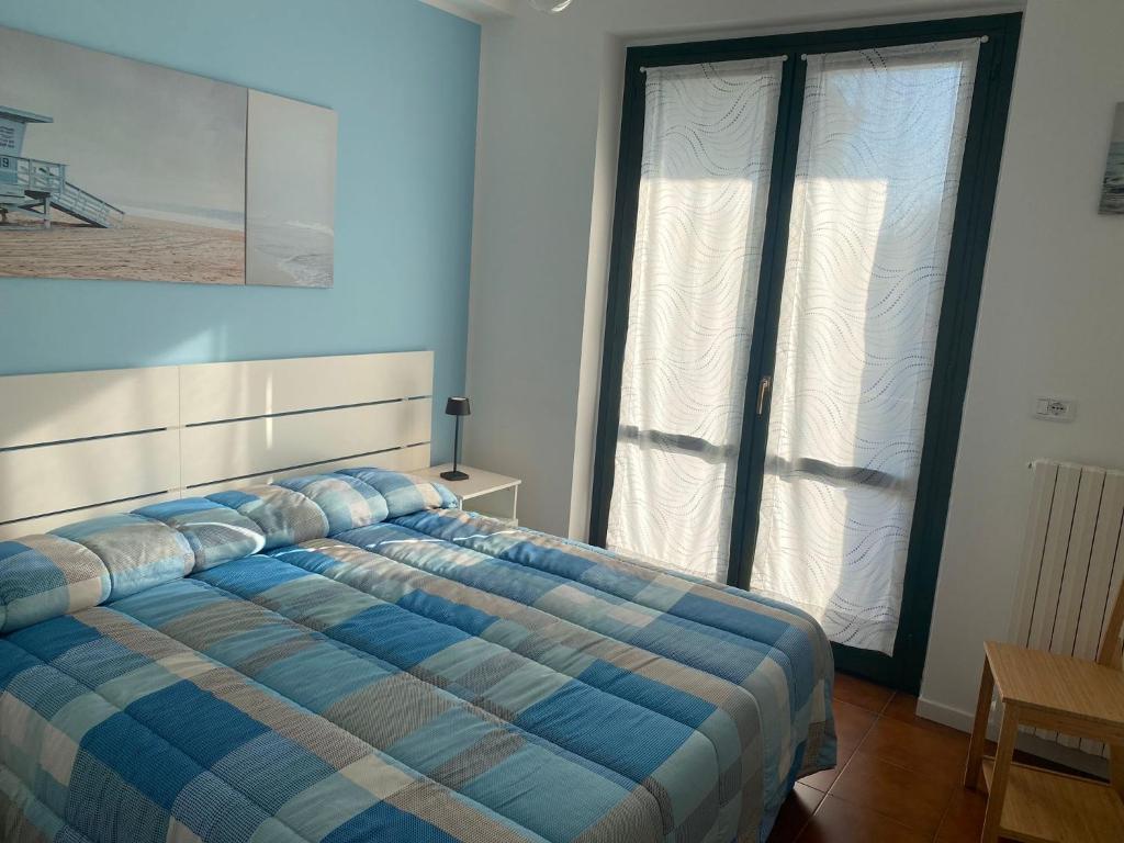 een slaapkamer met een blauw bed en een raam bij A casa di Nonna Maria in Marcelli