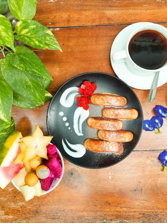 a plate of sausages on a table with a cup of coffee at Snooze in Yogyakarta