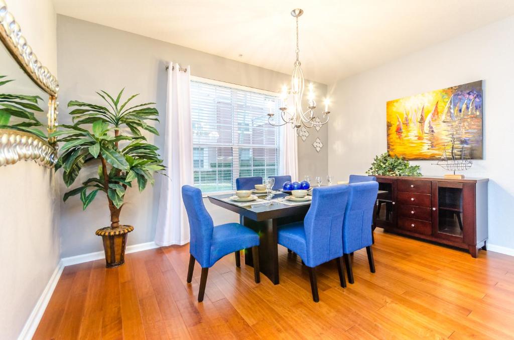 a dining room with a table and blue chairs at Spacious Condo in Vista Cay Resort LUXURY AWAITS in Orlando