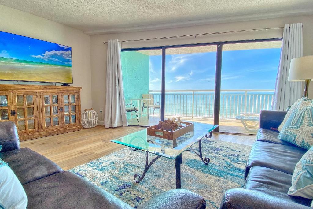 ein Wohnzimmer mit einem Sofa und einem Glastisch in der Unterkunft Chateaux Sunset Suites 408 in Clearwater Beach