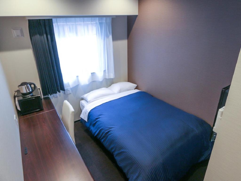 Postel nebo postele na pokoji v ubytování HOTEL LiVEMAX Yokohama Kannai Ekimae