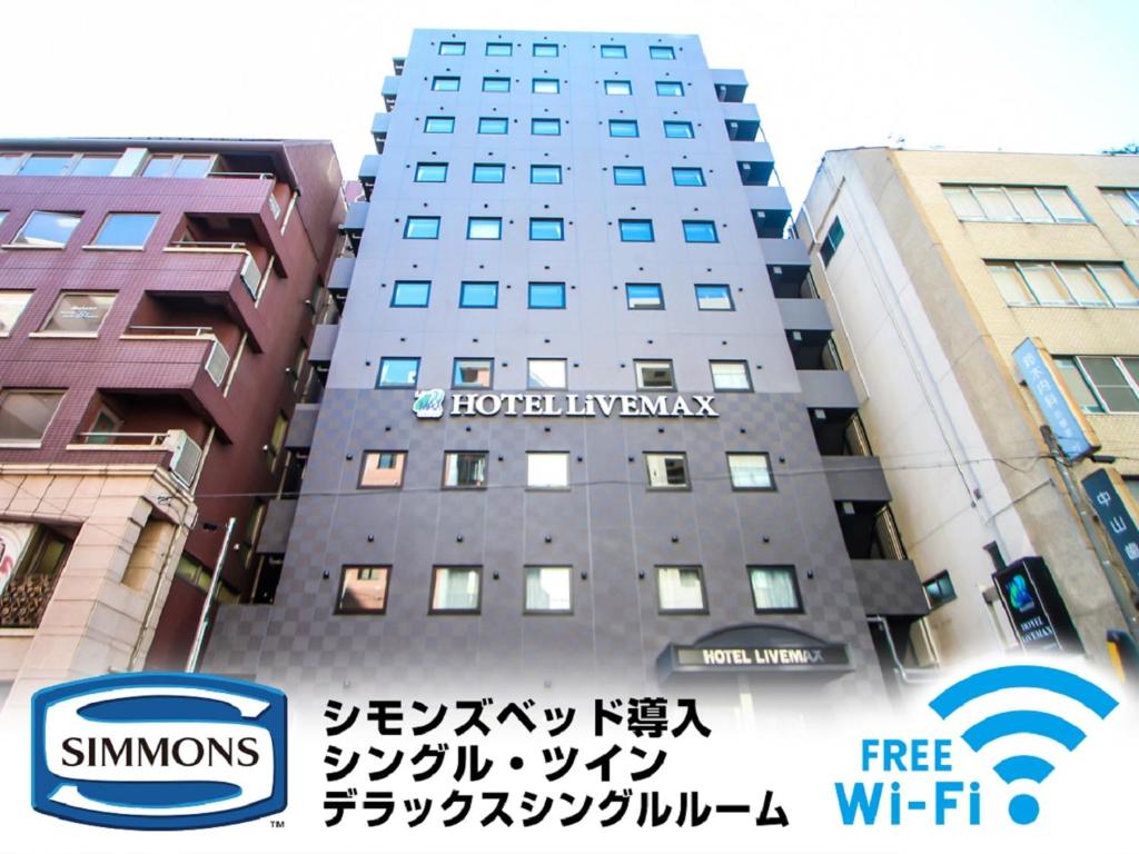 a building with a sign on the side of it at HOTEL LiVEMAX Yokohama Kannai Ekimae in Yokohama