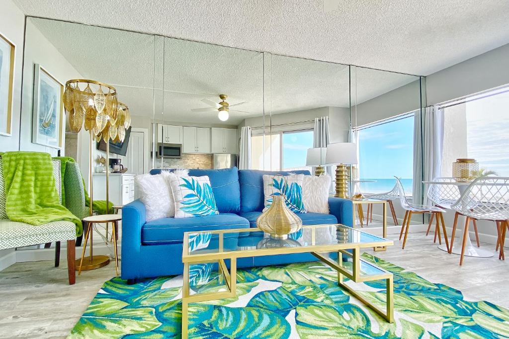 sala de estar con sofá azul y mesa en Belleair Beach Club 112, en Clearwater Beach