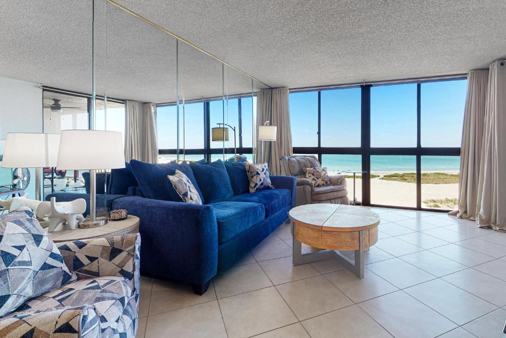 sala de estar con sofá azul y vistas al mar en Lighthouse Towers 704, en Clearwater Beach