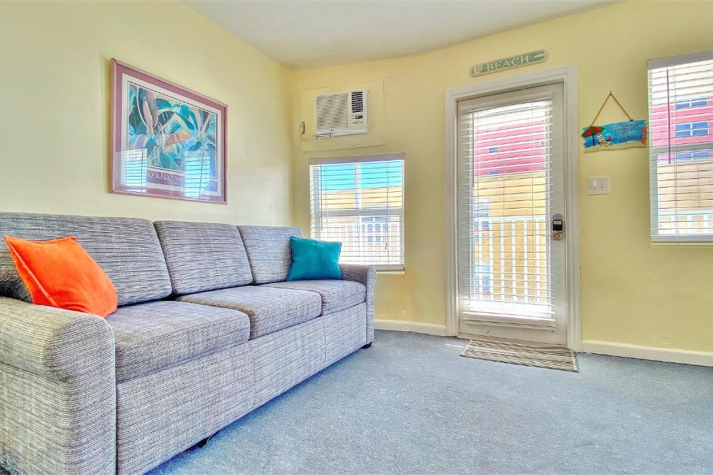 a living room with a couch and two windows at Sea Rocket 21 in St. Pete Beach