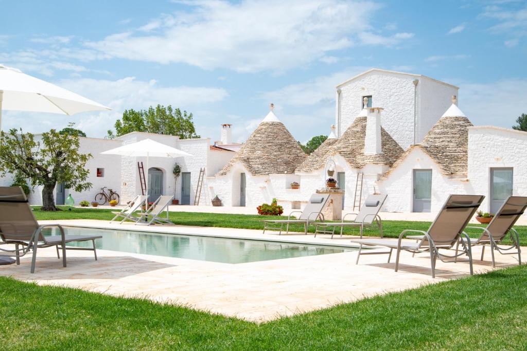 a house with a swimming pool and lawn at Dimore Angiulli - Trulli di Charme in Castellana Grotte