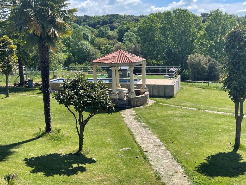 un cenador en un parque con dos palmeras en Casa Calvés, en Aviá