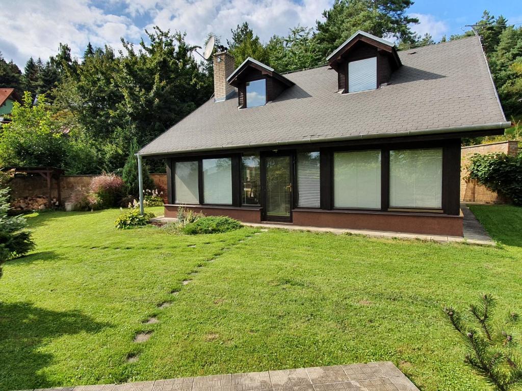 a house with a green yard with a house at Garden View in Drienica